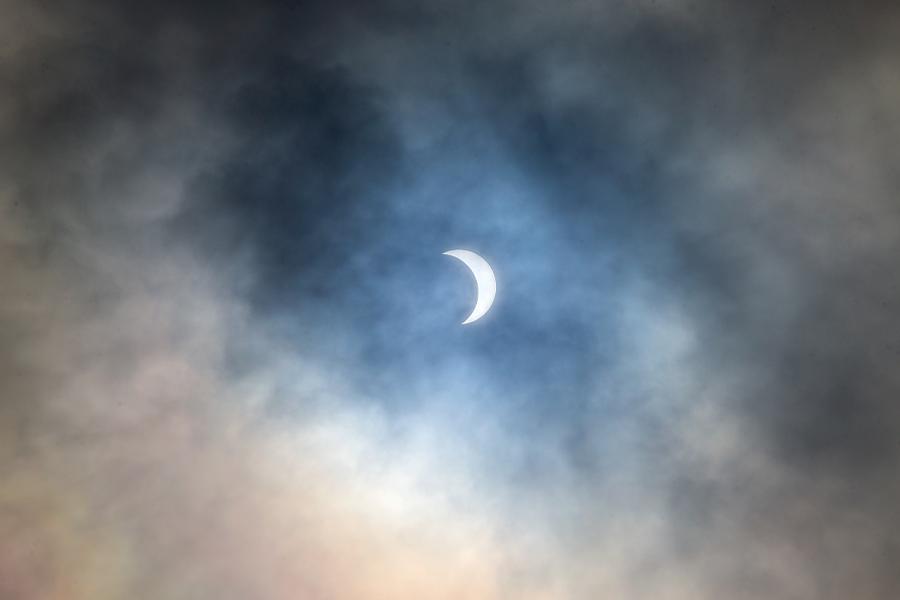 A solar eclipse surrounded by clouds.