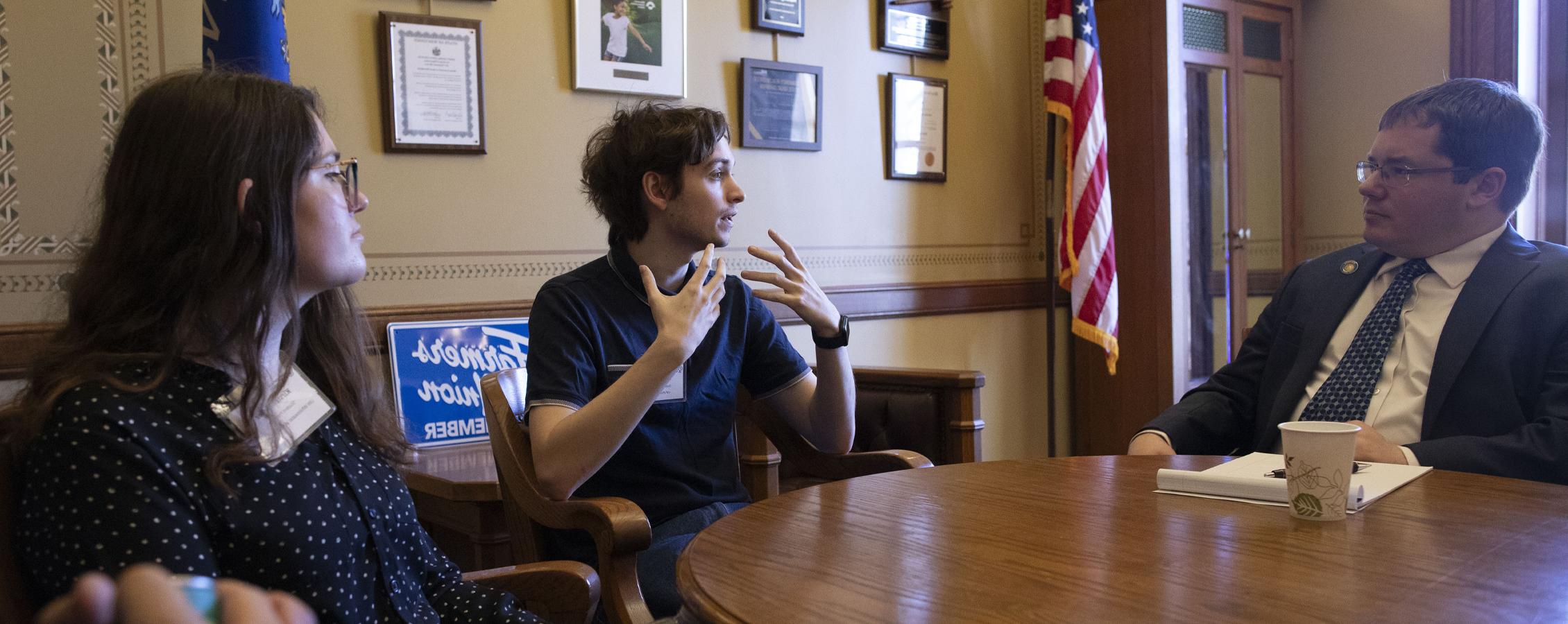 A psychology student talks with a senator at the Wisconsin State Capitol.