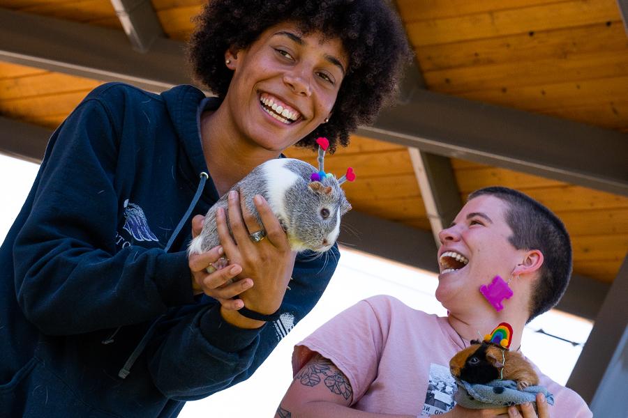 Two students hold guinea pigs.