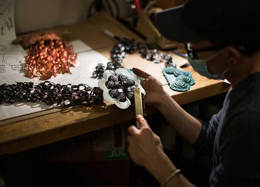 A student works on copper and brass pieces.